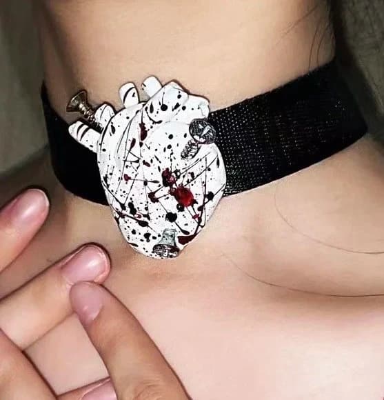 Heart-shaped pendant on a black choker.